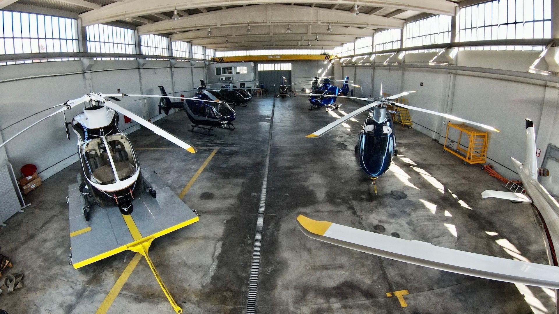 Inside the hangar: looking down the centre aisle between parked helicopters